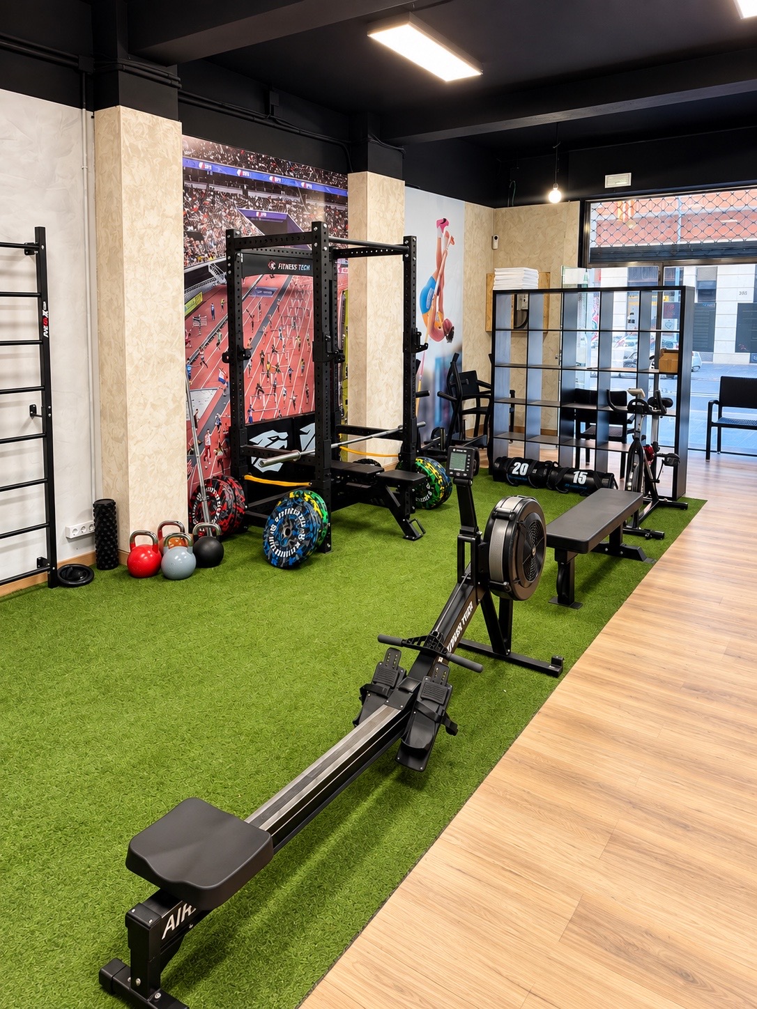 Zona de entrenamiento de BOX55 con remo, rack y pesas